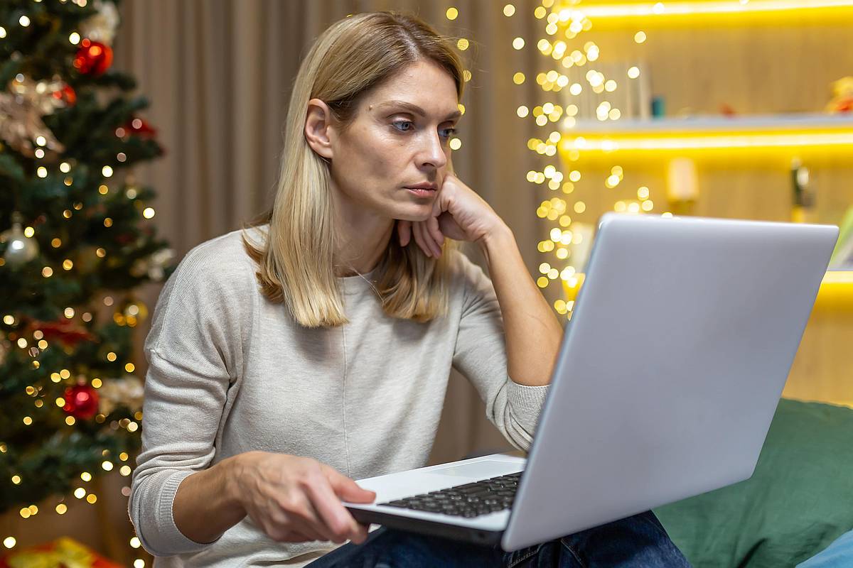 IT manažerka se dívá na svůj notebook u vánočního stromku